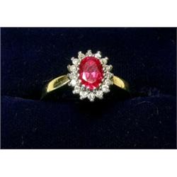 An 18ct gold ring set with a synthetic ruby within a diamond surround  £170-200...