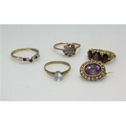 A 9ct gold three stone garnet ring, three other gem set rings and an oval amethyst and seed pearl b.