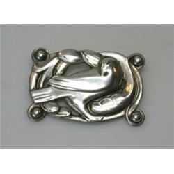 An American hollow silver brooch, rectangular formed as a dove within a beaded scrolled frame in th.