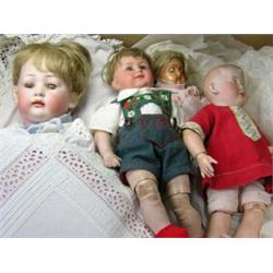 A collection of four various dolls, to include: a Heubach bisque headed boy doll with painted eyes..