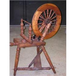 A late 19th century spinning wheel, the wooden wheel with spindle turned spokes and supported on fr.