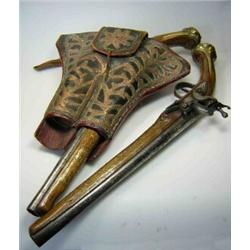 A pair of Arabian flintlock pistols and holster, the wood work of the weapons inlaid with brass and.