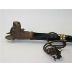 A carved dog's head walking cane, the animal with glass eyes and opening mouth, the cane later and..