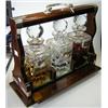 Image 1 : A mahogany tantalus, together with three cut glass decanters and three silver labels for Whisky, Gi.