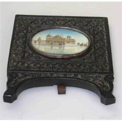 A late 19th century Indian miniature in foliate carved ebony easel frame, the oval painting depicti.