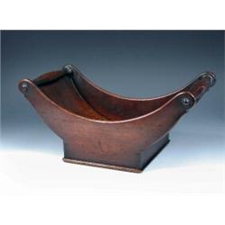 An early 19th century mahogany cheese coaster, the boat shape with spindle ends to form handles abo.