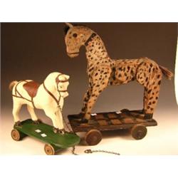 Two pull along horses, one built of sections of carved wood applied with plaited mane and horse hai.