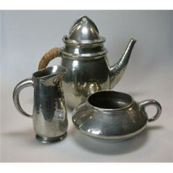 A Tudric Pewter three piece coffee set comprising a coffee pot of tapering circular shape, hammered.