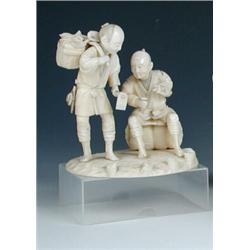 An early 20th century Japanese ivory and shark's tooth group of two workmen, one standing holding a.