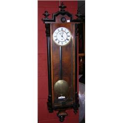 A weight driven Vienna regulator wall clock, the finial mounted arched cornice above a long glazed d