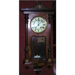 A spring driven Vienna wall clock, the moulded cornice above a glazed door enclosing a white enamel.