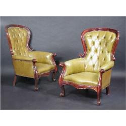 A pair of mahogany framed leather covered armchairs, each with moulded top rail above a button padd.