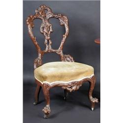 A Victorian single chair, the shaped back naturalistically carved above an overstuffed seat, standi.