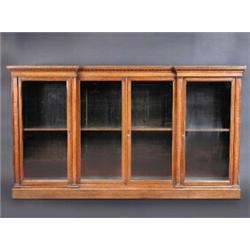 A Victorian oak inverted breakfront floor standing bookcase, the shaped top above a beaded frieze a.