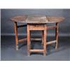 Image 1 : An 18th century oak drop leaf table, the circular twin flap top above an end frieze drawer, standin.