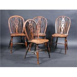 A Set of three yew wood and elm wheelback Windsor chairs, with saddle shaped seats and turned legs..