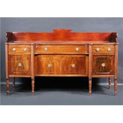 A Regency mahogany sideboard, the shaped top with reeded edge and solid three quarter gallery above.