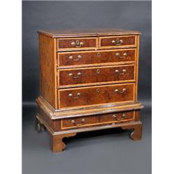 An early 18th century oyster veneered chest on stand, the upper section with parquetry inlaid and c.