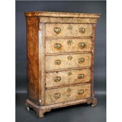 A walnut chest, the moulded cornice fitted with a drawer above five long graduated drawers, standin.