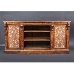 A Victorian figured walnut floor standing breakfront bookcase, the moulded shaped top above open ad.