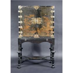 A Chinoiserie decorated lacquered cabinet on stand, the upper section with a pair of brass mounted..