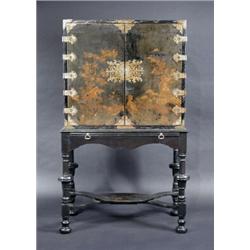 A Chinoiserie decorated lacquered cabinet on stand, the upper section with a pair of brass mounted..