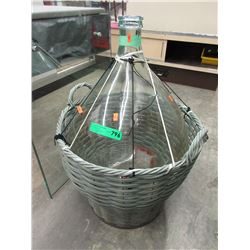 Glass demi-john in basket - used