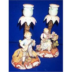 a pair of german porcelain candlestick bases, c.1900, with figures of children, hatched mark....