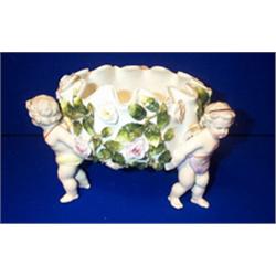 A SITZENDORF BOWL, c.1900, encrusted with roses and supported by three standing putti, hatched...