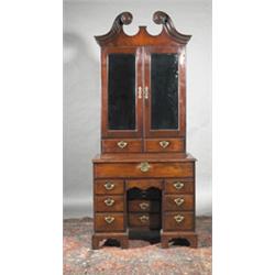 A MAHOGANY WRITING CABINET, IRISH, MID 18th CENTURY, the top part with bold swan neck broken p...