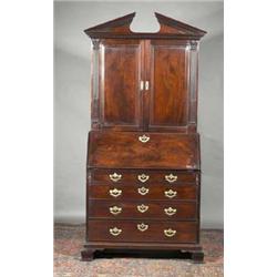 A MAHOGANY BUREAU CABINET, IRISH, 18th CENTURY, the top part with a broken triangular pediment...