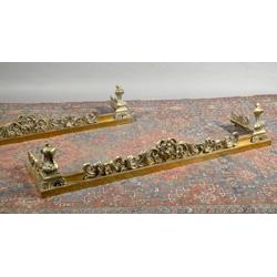 A PAIR OF GILT BRASS FENDERS, c1900, with central scrolled crestings, and with tall sectioned...