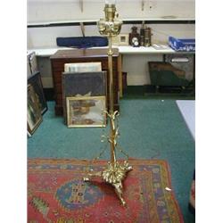 A BRASS FREESTANDING PARAFIN LAMP, early 20th century, whip lash tendrills, tripod stand, height...