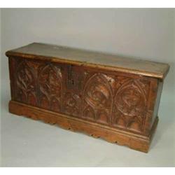 A 17th Century Spanish oak coffer with moulded planked top, wrought iron lock and carved gothic a...
