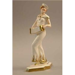 A Royal Dux art deco figure of a lady playing a concertina. 11.5ins...