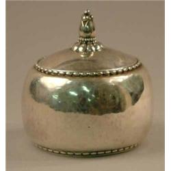 A George Jensen oval box and cover with lightly hammered body and floral knop, 1920 and numbered...