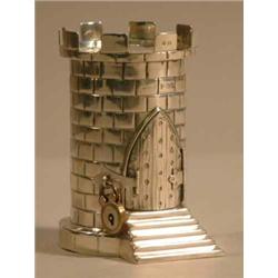 An Edwardian silver money box, in the form of a turret with steps leading to a padlocked door, Bi...