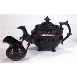 Victorian black basalt teapot and milk jug, relief moulded with a band of flowers, leaves and berrie