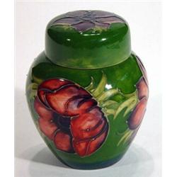 Moorcroft ginger jar and cover hand painted and tubelined with anemones onto a dark green ground, im