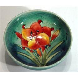 Moorcroft shallow bowl hand painted and tubelined with 'African Lily' onto a light blue ground, impr