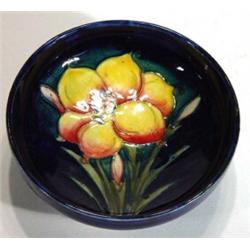 Moorcroft shallow bowl hand painted and tubelined with 'African Lily' onto a dark blue ground, impre