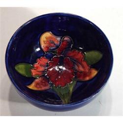 Small Moorcroft bowl hand painted and tubelined with orchids onto a blue ground, impressed marks to 