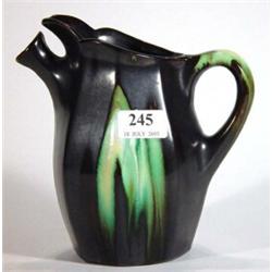 Black and green glazed Continental pottery jug with spout, marks to base, 20cm high