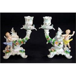 Pair of hand painted Continental porcelain cherub design candlesticks relief moulded with flowers, b