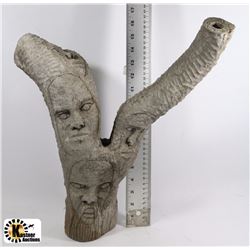 WOOD FACES ON TREE BRANCH