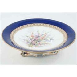 A Victorian bone china comport, painted with wild flowers within a seed-pearl and royal blue bord...