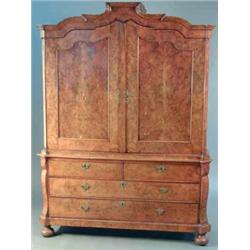 An early 19th century Dutch figured walnut armoire, with moulded scroll pediment and two fielded...