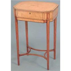 An Edwardian Sheraton design satinwood work table, of octagonal form, on ebony strung square tape...