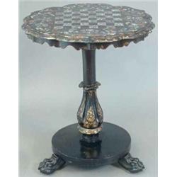 A Victorian papier-mache and ebonised games table, the pie crust circular top painted and shell i...