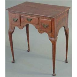 A George III oak lowboy, with 3 small drawers and shaped apron on slender tapered legs with pad f...